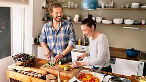 RUNNER'S WORLD Ernährungscoaching Ein junges Pärchen hat Spaß beim gemeinsamen Kochen. RUNNER'S-WORLD-Ernährungscoaching.