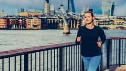 Junge Läuferin, die an einem Fluss joggt