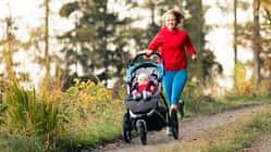 Joggen nach Kaiserschnitt: Laufende Mutter mit ihrem Kind in einem Babyjogger