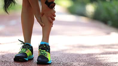Läuferin mit Schmerzen im Schienbein