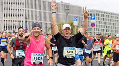 Zwei Läufer um die 50 jubeln beim Berlin-Marathon.