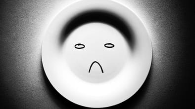 Leerer Teller mit einem unglücklichen Smiley.