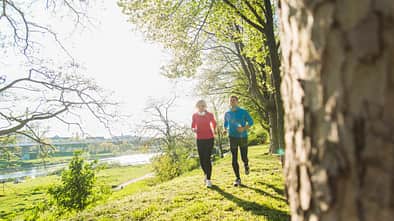 Fit in den Frühling: Zwei Menschen genießen das Lauftraining.