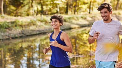 Couple jogging on autumnally forest track