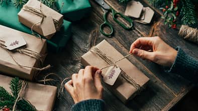 Eine Frau packt Weihnachtsgeschenke ein. 