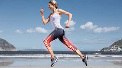 Läuferin am Strand mit illustrierten Knochen in den Beinen.