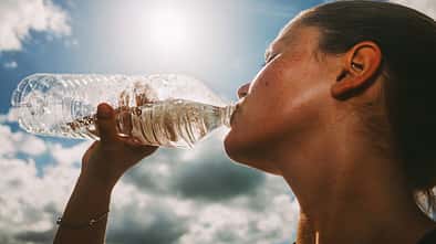 Eine Sportlerin trinkt Wasser.