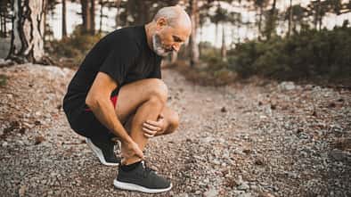 Ein Läufer hält sich den schmerzenden Knöchel.