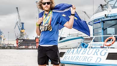 Tim ­Teege im Hamburger ­Hafen mit einer kleinen Auswahl der Finisher­medaillen der letzten Jahre.