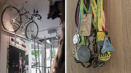 Ein Rennrad, ein Ironman-Plakat und etliche Medaillen zeugen von sportlicher Expertise. Ein Rennrad, ein Ironman-Plakat und etliche Medaillen zeugen von sportlicher Expertise.