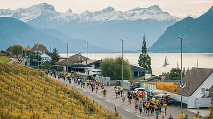 Läufer auf einer schmalen Straße zwischen Alpenpanorama und gelben Weinbergen. Läufer auf einer schmalen Straße zwischen Alpenpanorama und gelben Weinbergen.