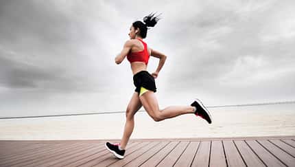 Junge Frau mit definierten Muskeln beim Lauftraining