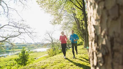 Fit in den Frühling: Zwei Menschen genießen das Lauftraining.