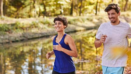 Couple jogging on autumnally forest track