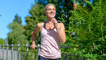 Happy healthy woman jogging outdoors