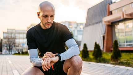 Athlete Checking Fitness Activity On Fitness Tracker After Working Out Outdoors