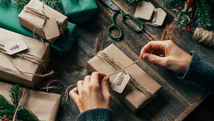 Eine Frau packt Weihnachtsgeschenke ein. 