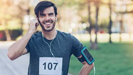 Smiling athlete with headphones and arm band