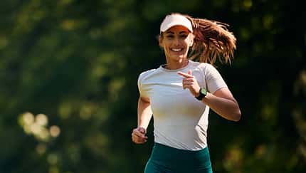 Happy female athlete running in the park.
