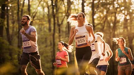 Large group of motivated runners running a marathon in nature.