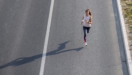 Eine ambitionierte Läuferin beim Training auf der Straße (Aufnahme von schräg oben) – Trainingsplan Marathon unter 3:50 Stunden
