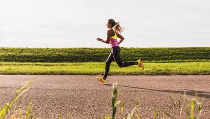 Progressionslauf: Eine Sportlerin läuft zügig auf einer Straße.