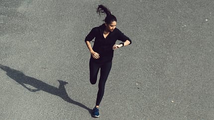 Minimaltraining: Eine Läuferin schaut während des Trainings auf ihre Sportuhr.