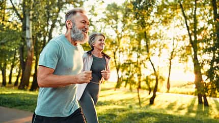 Laufen im Alter Laufen im Alter: Ein Läufer und eine Läuferin im mittleren Alter trainieren gemeinsam