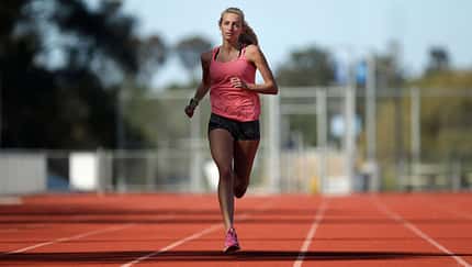 Läuferin beim intensiven Training auf der Laufbahn Läuferin beim intensiven Training auf der Laufbahn