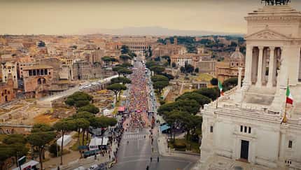 Luftaufnahme vom Start des Rom Marathons, weißes historisches Gebäude im Vordergrund.