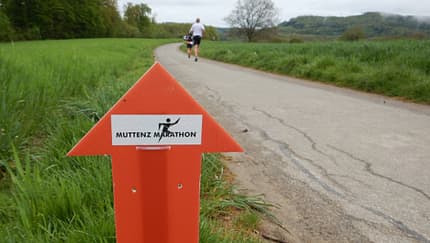 Ein orangefarbenes Richtungsschild und verschwommene Landschaft im HIntergrund. Ein orangefarbenes Richtungsschild und verschwommene Landschaft im HIntergrund.