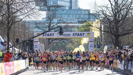 Läufer beim Start vor Glas-Gebäude und Zuschauern. Läufer beim Start vor Glas-Gebäude und Zuschauern.