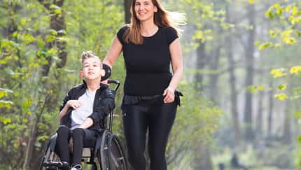 Yasmine Beyaz läuft mit ihrem Sohn, der im Rollstuhl sitzt
