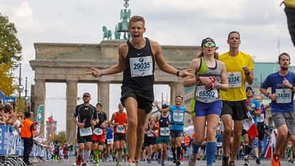 Marathonläufer jubelt vorm Brandenburger Tor