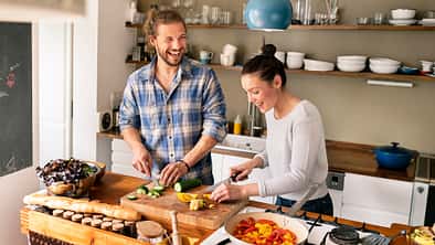 Ein junges Pärchen hat Spaß beim gemeinsamen Kochen. RUNNER'S-WORLD-Ernährungscoaching.