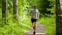 Das richtige Lauftempo: Junger Mann joggt durch lichten Wald