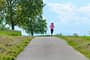 Welche Geschwindigkeit beim Joggen? Eine Frau läuft entspannt auf einer Straße.