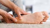 Man hands giving foot massage to yourself after a long walk