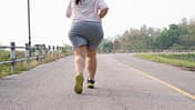 Laufen gegen Reiterhosen: Eine mollige junge Frau joggt auf einer Straße.