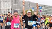 Zwei Läufer um die 50 jubeln beim Berlin-Marathon.