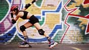 Inlineskating: Eine Frau mit Schutzausrüstung fährt auf Inlineskates.