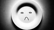 Leerer Teller mit einem unglücklichen Smiley.