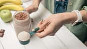 Eine Frau bereitet einen Shake aus Proteinpulver zu.