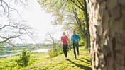 Fit in den Frühling: Zwei Menschen genießen das Lauftraining.