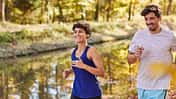 Couple jogging on autumnally forest track