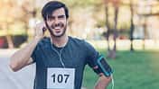 Smiling athlete with headphones and arm band