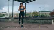 Hybrid-Training: Eine Sportlerin trainiert an einer Koordinationsleiter.