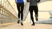 Joggen mit O-Beinen: Nahaufnahme einer Läuferin und eines Läufers von hinten, sie hat leichte X-Beine, er O-Beine.