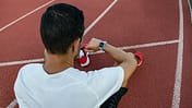 Man looking at the smartwatch after working out. Sports technology concept