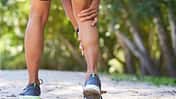 Close up of man holding calf in pain, sports injury trail run, cramp